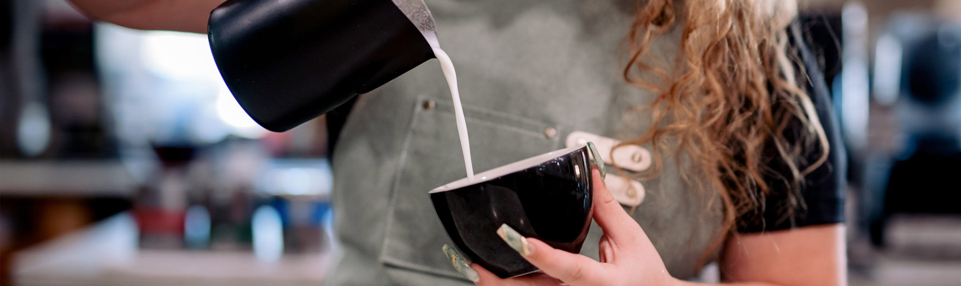 Barista pouring milk for latte art training