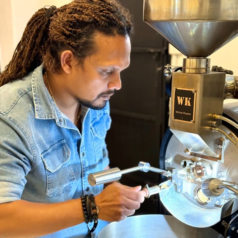 Nirodha Jayakody working with coffee roasting equipment
